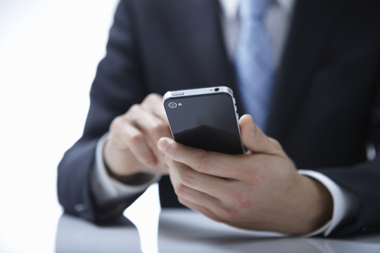 スマホで仮想通貨取引をするイメージ